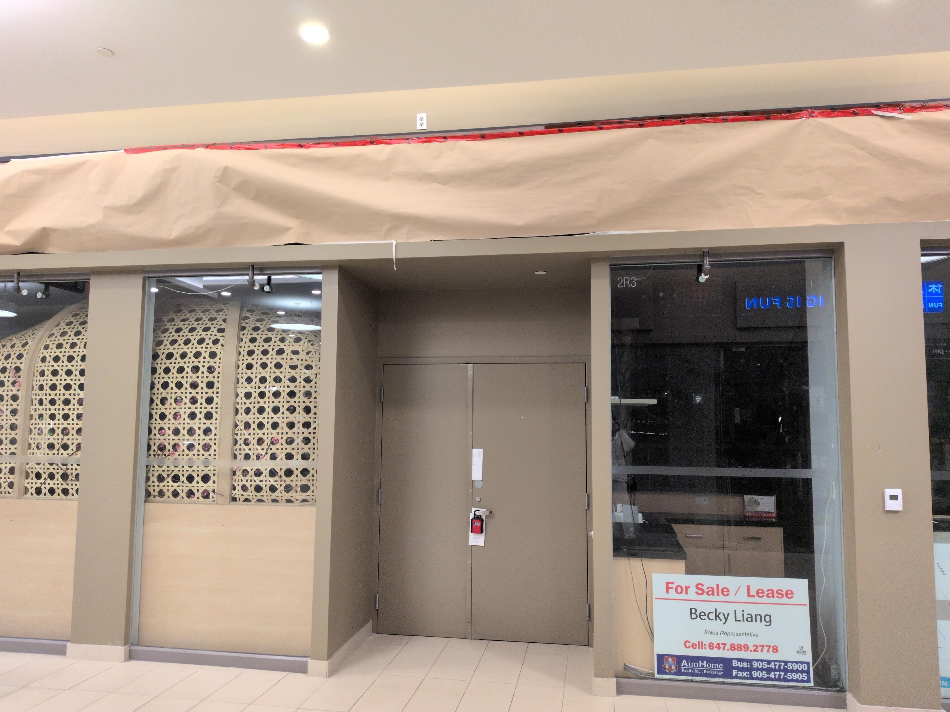 Photo of restaurant with locked closed doors and shuttered windows and covered sign and a for lease sign from a realtor