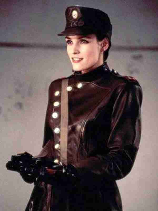 photo of Xenia Onatopp from Goldeneye (Famke Janssen, white woman in a black hat and black leather suit with side buttons) holding a gun and grinning