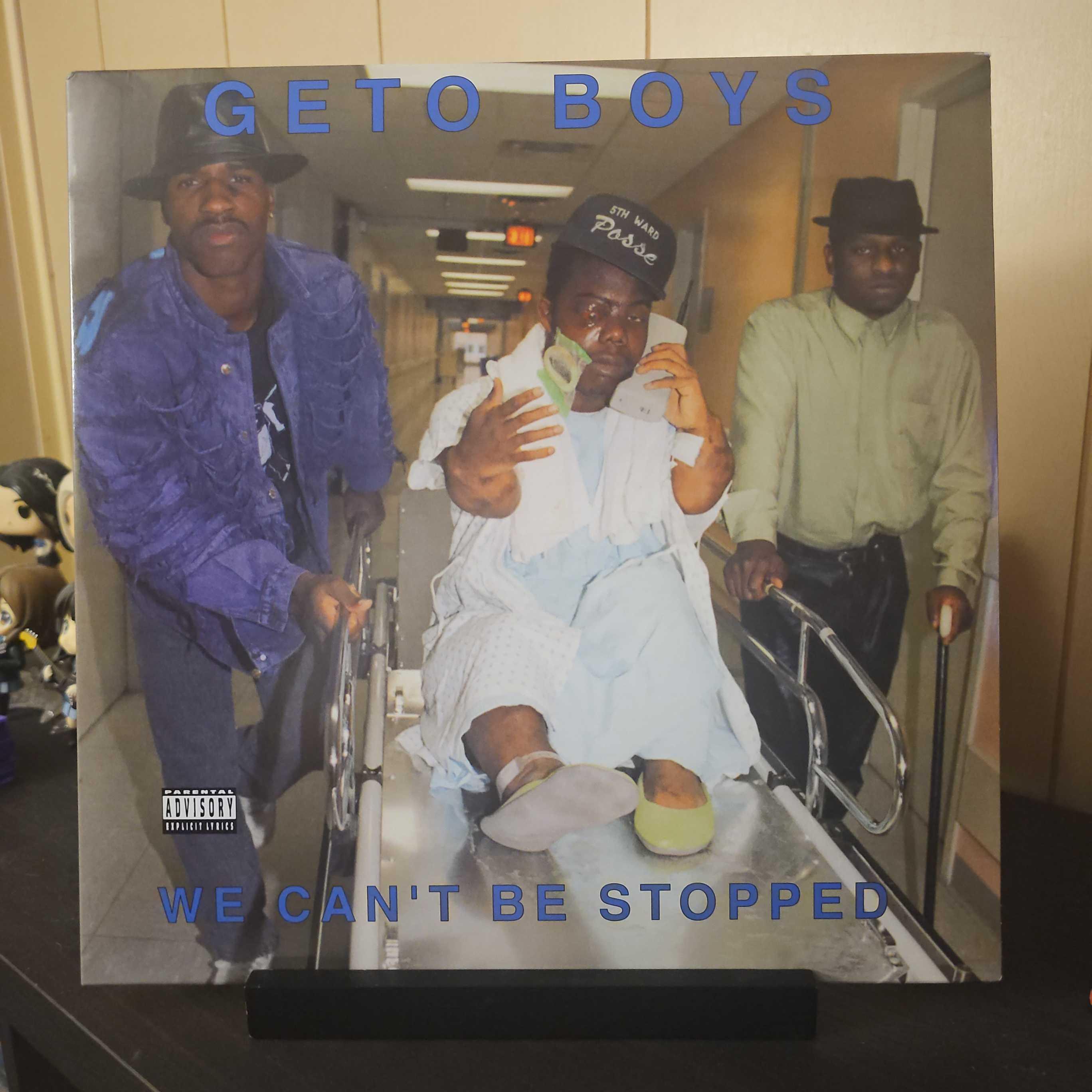 A vinyl record album outer sleeve is displayed. The front cover shows Willie D and Scarface pushing Bushwick Bill on a metal hospital bed. Bill has a messed up eye and talking on a old style cell phone.